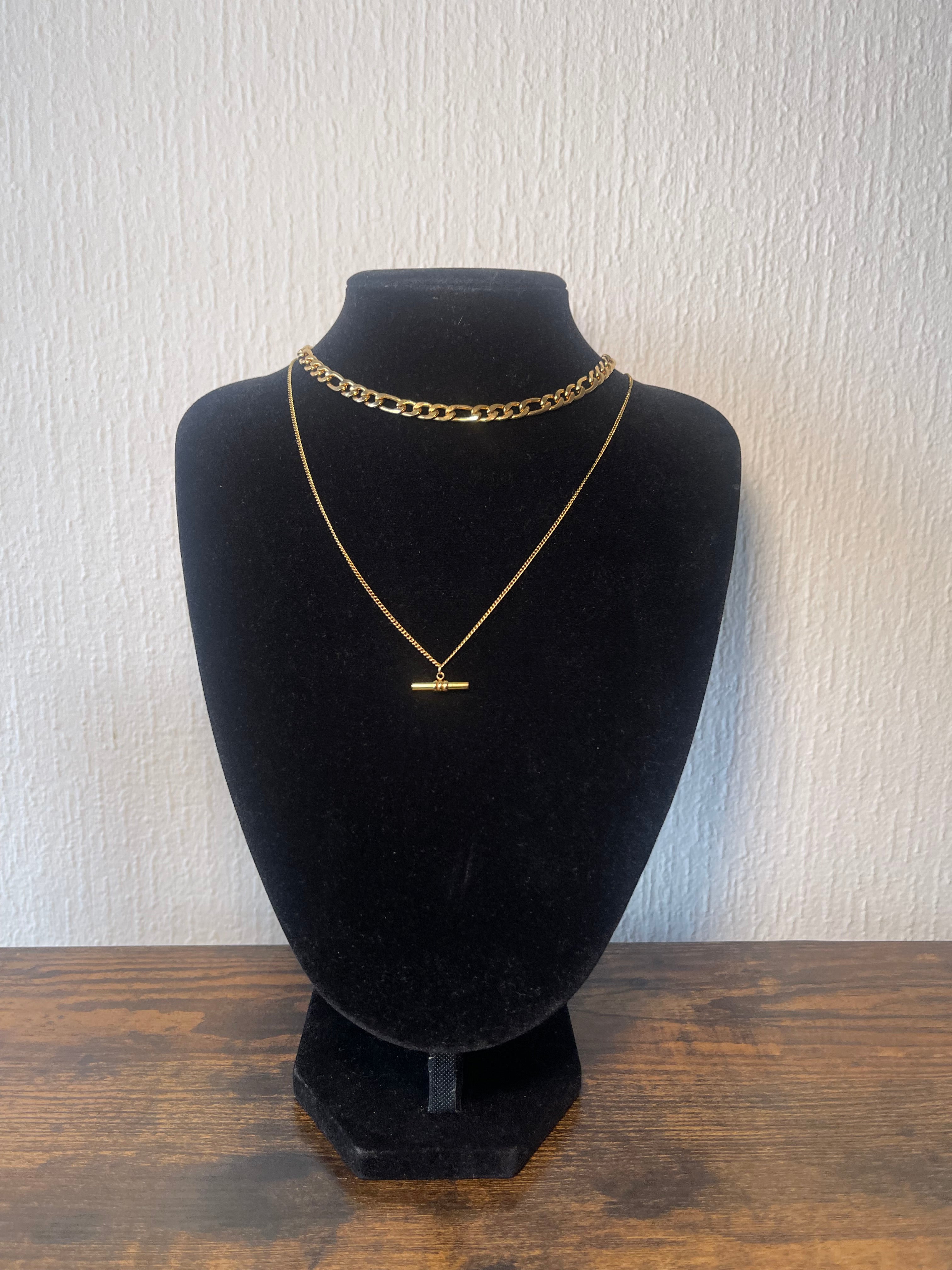 Minimalist STELLA necklace with slender horizontal gold-tone bar on adjustable fine chain layered with chunky link choker on black velvet display bust