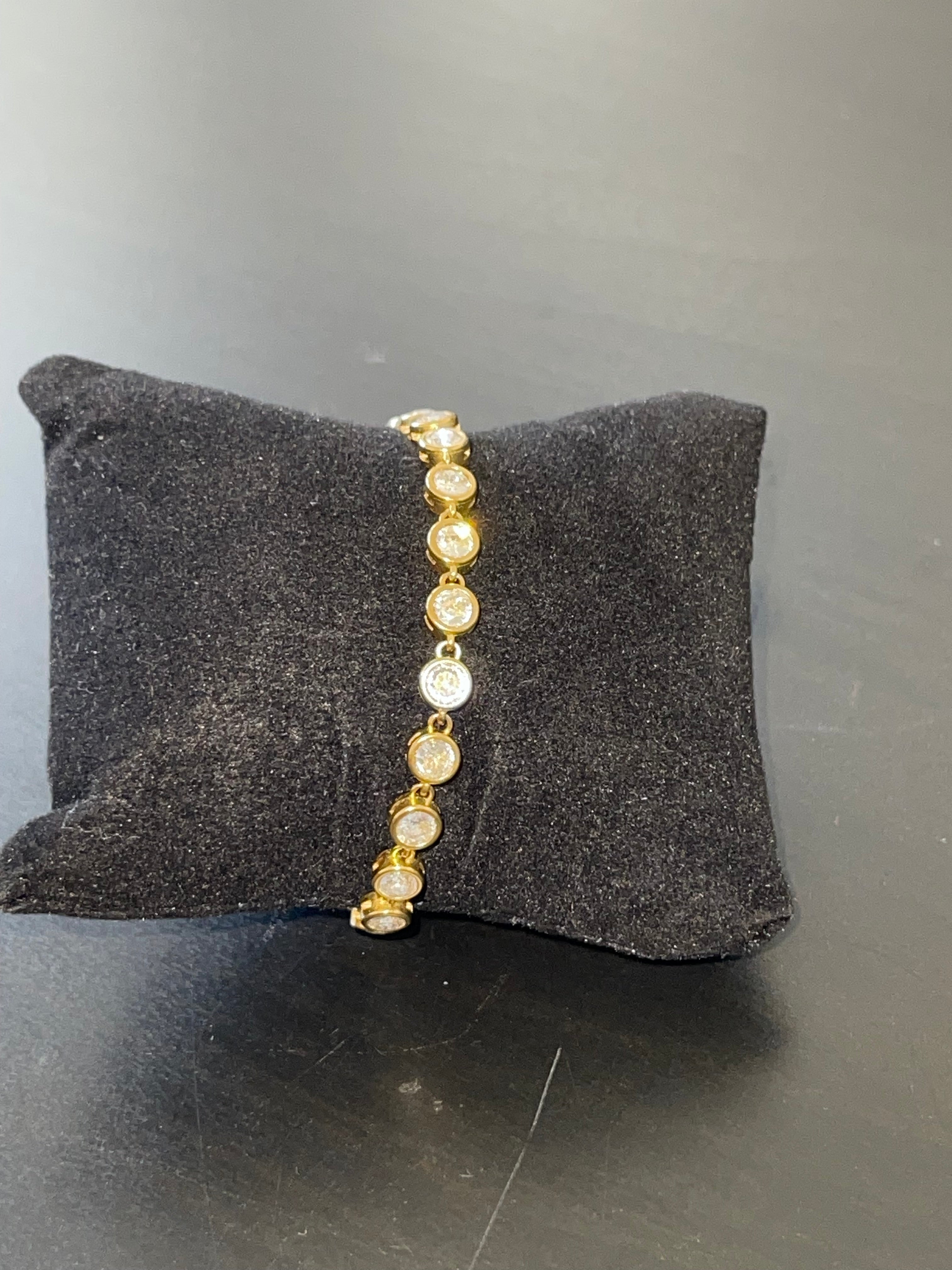 Clarisse Tennis Bracelet with round bezel-set cubic zirconia stones in 18k gold-plated stainless steel displayed on black cushion