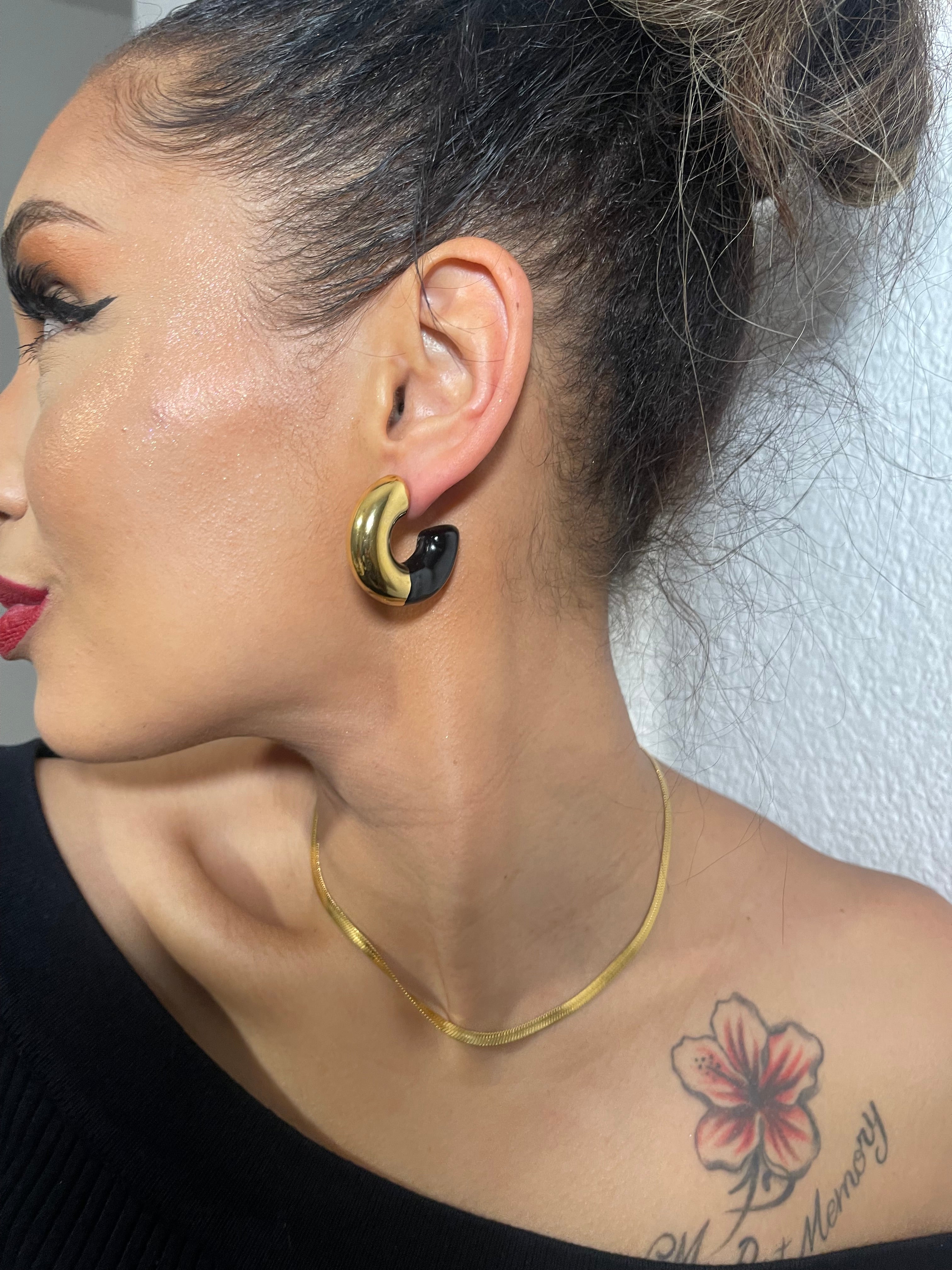 Chunky small hoop earrings in gold, worn by model, showcasing versatility and elegance.