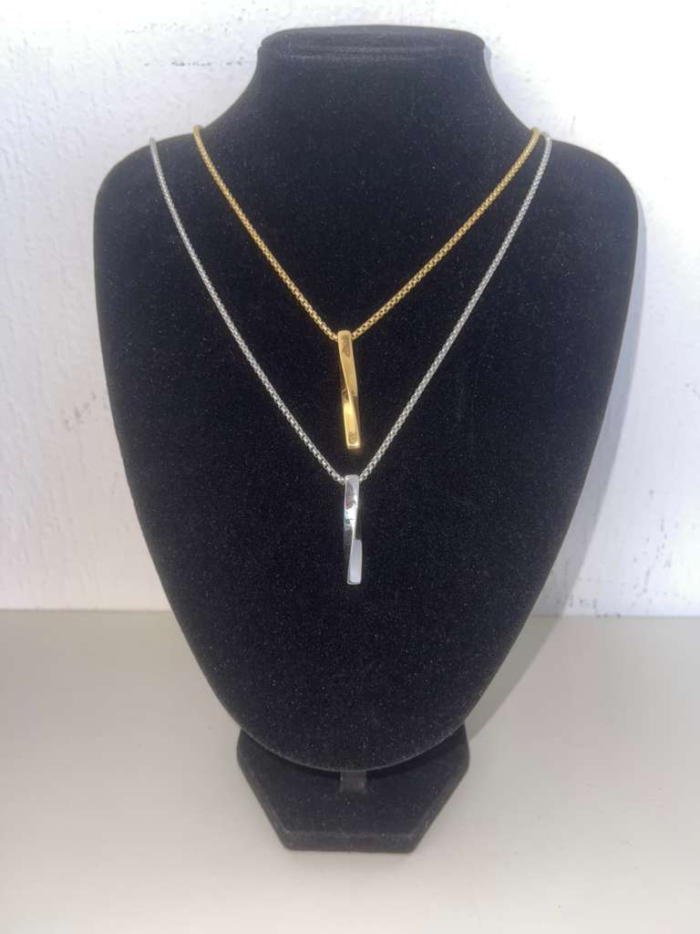 LUCA Necklace minimalist gold and silver stainless steel chains with sleek vertical pendants on black display bust