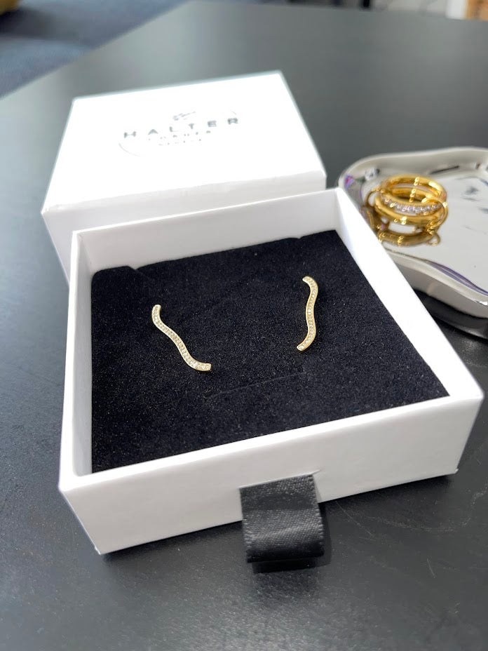Delicate curved Sophie Earrings with 18k gold plating and cubic zirconia in a white jewelry box