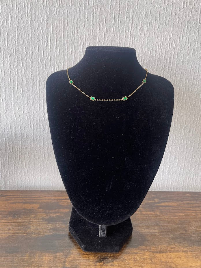 EMILIA emerald necklace with rectangular emerald-green cubic zirconia stones on a delicate gold-plated chain displayed on a black jewelry bust