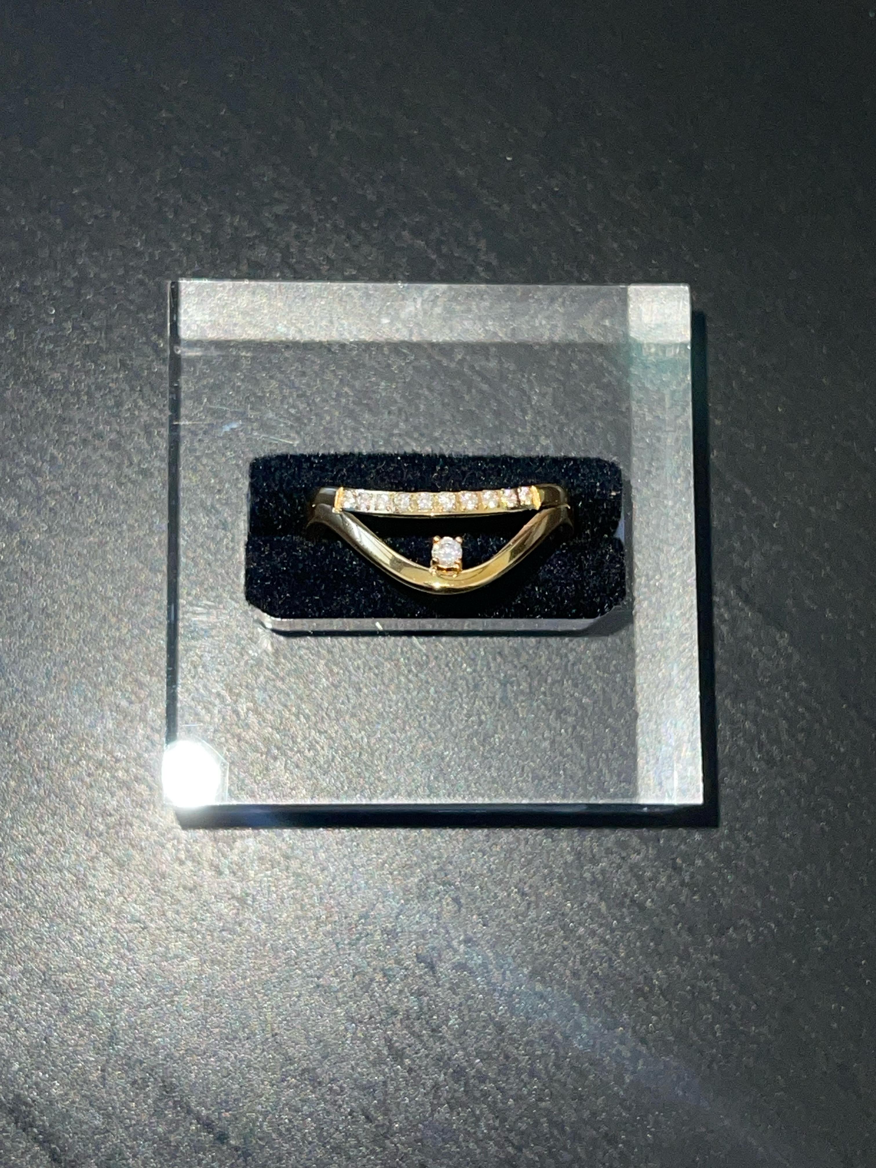 Shelley Ring gold-plated V-curve design with cubic zirconia stones and single gem on black cushion display